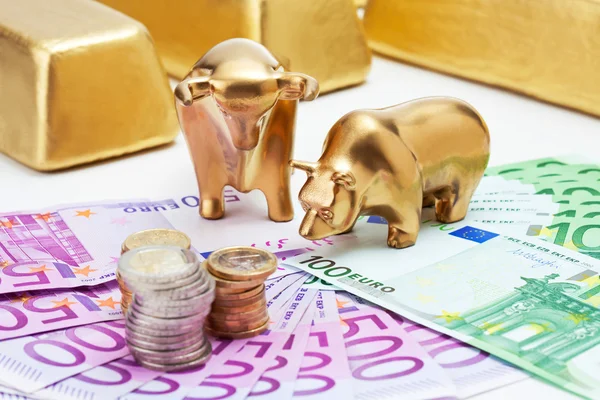 Золотой медведь, раздували бык фигурки с евро монеты золотые полосы на Стоковая Картинка