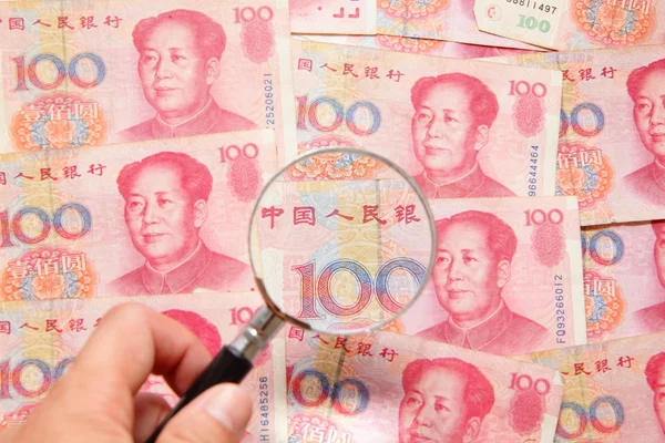 Китайские деньги (валюта) и увеличительное стекло Стоковая Картинка