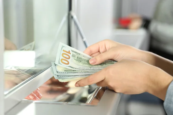 Женская рука с деньгами в наличном окне отдела. понятие обмена валюты Стоковое Изображение