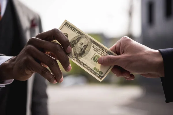 Анонимные бизнесмены руки сто тысяч долларов банкноты на открытом воздухе Лицензионные Стоковые Изображения
